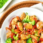 Top down view of bowl of chicken stir fry in wicker tray