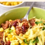 Up close shot of a bowl of chili and cheese.