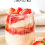 A strawberry cheesecake cup on a plate.