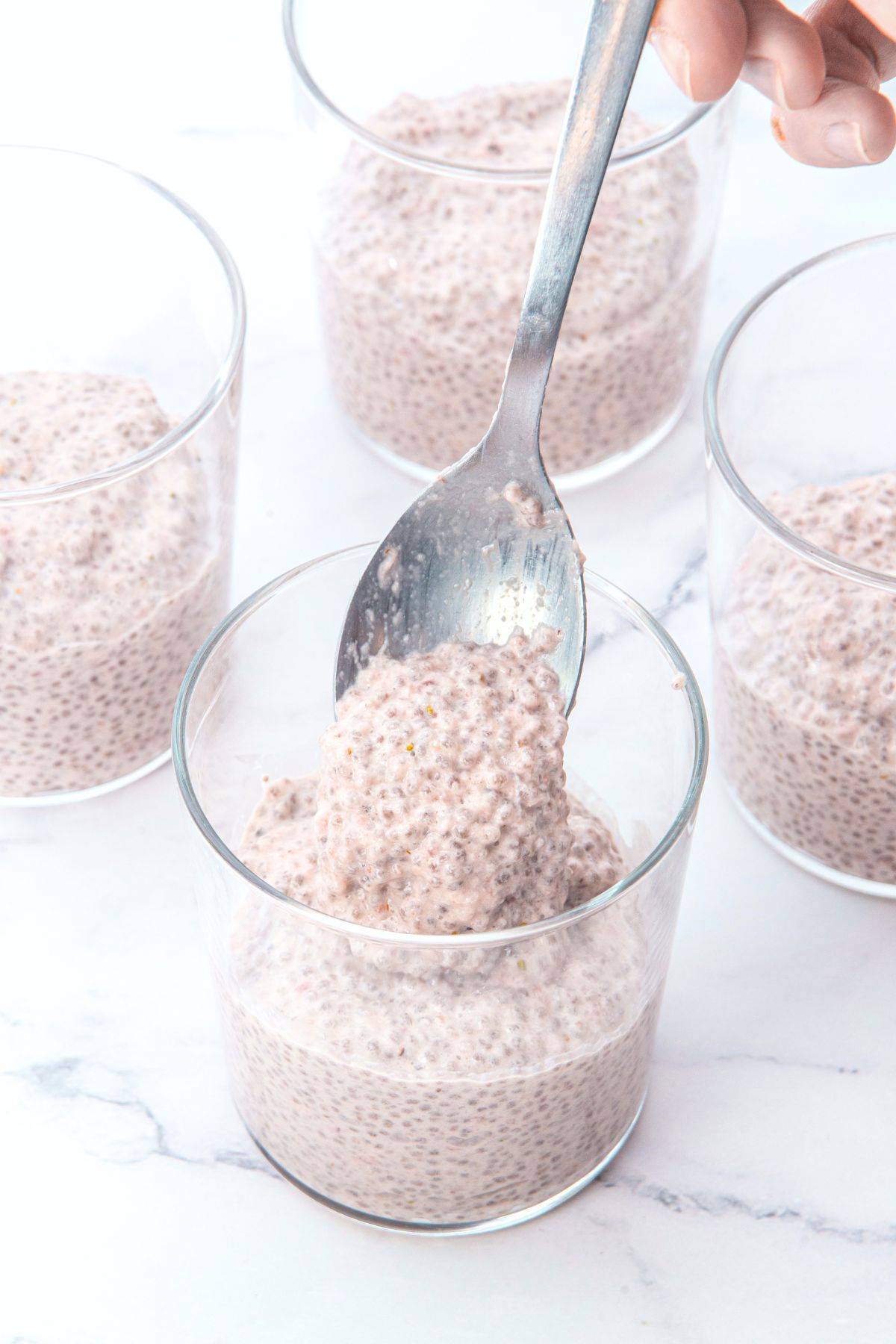Scooping chia pudding into glasses