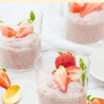 Up close view of glass of strawberry chia seed pudding on plate.