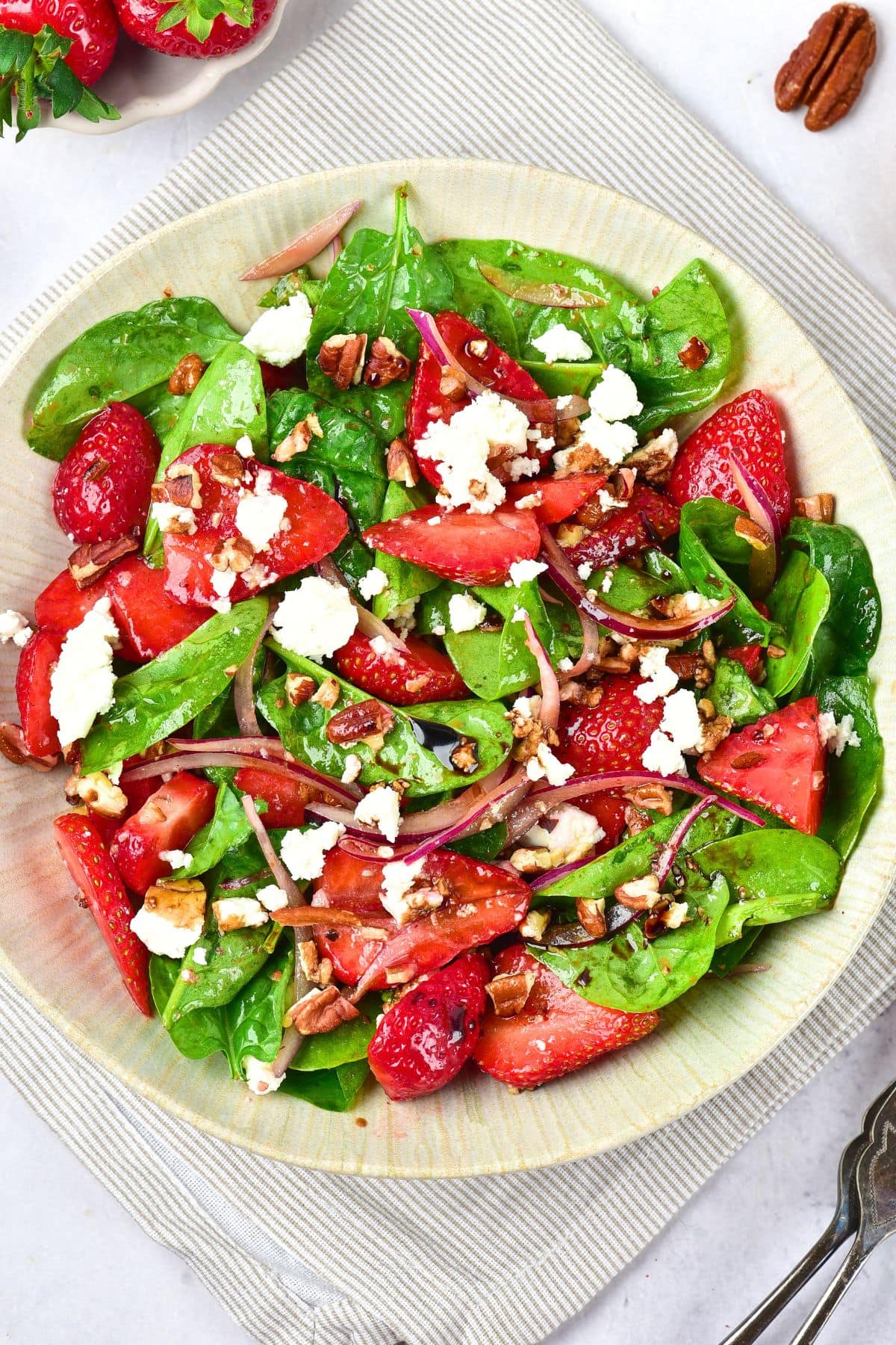 Top down view of a bowl of strawberry spinach salad with balsamic dressing