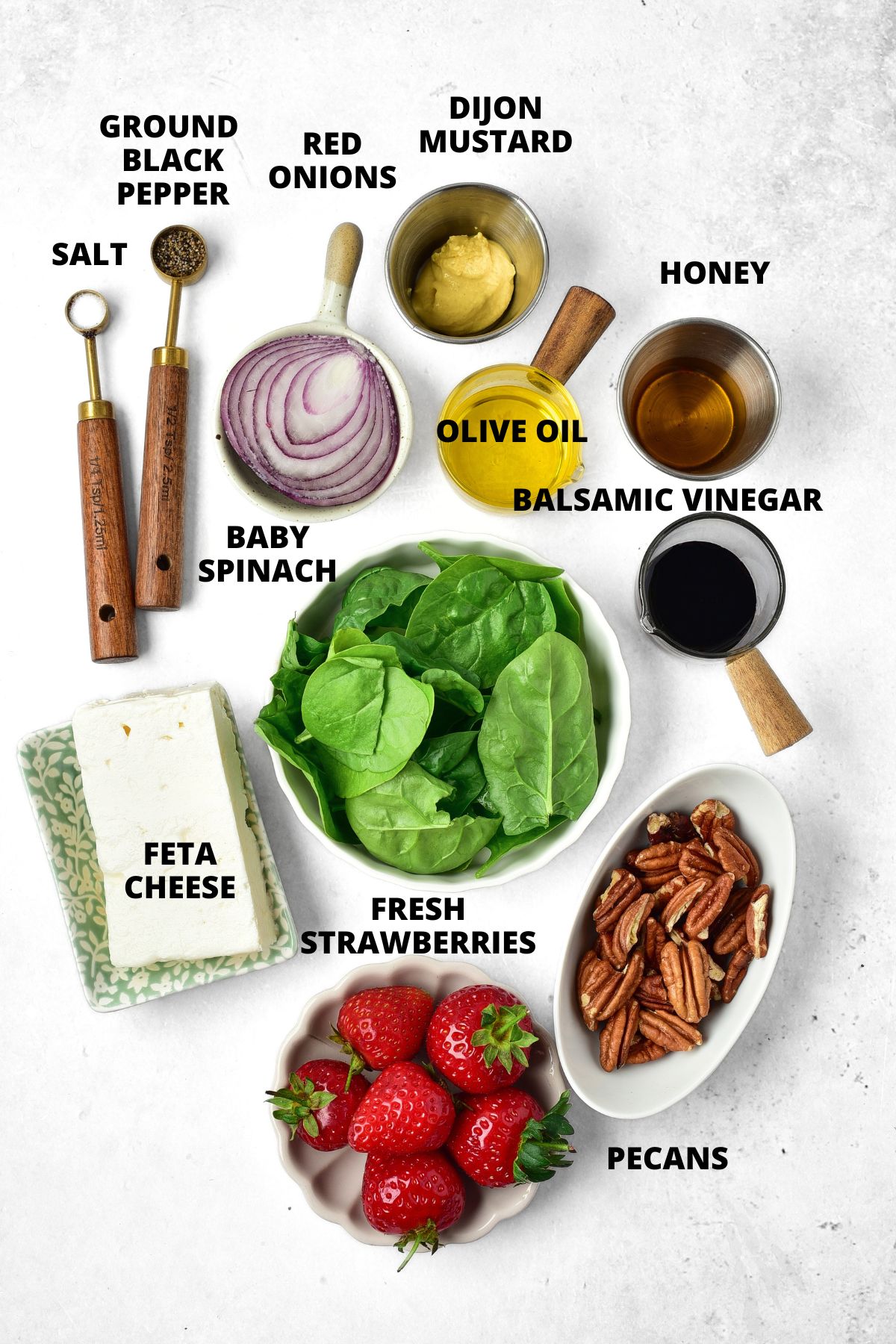 Ingredients for strawberry spinach feta salad recipe laid out on board.
