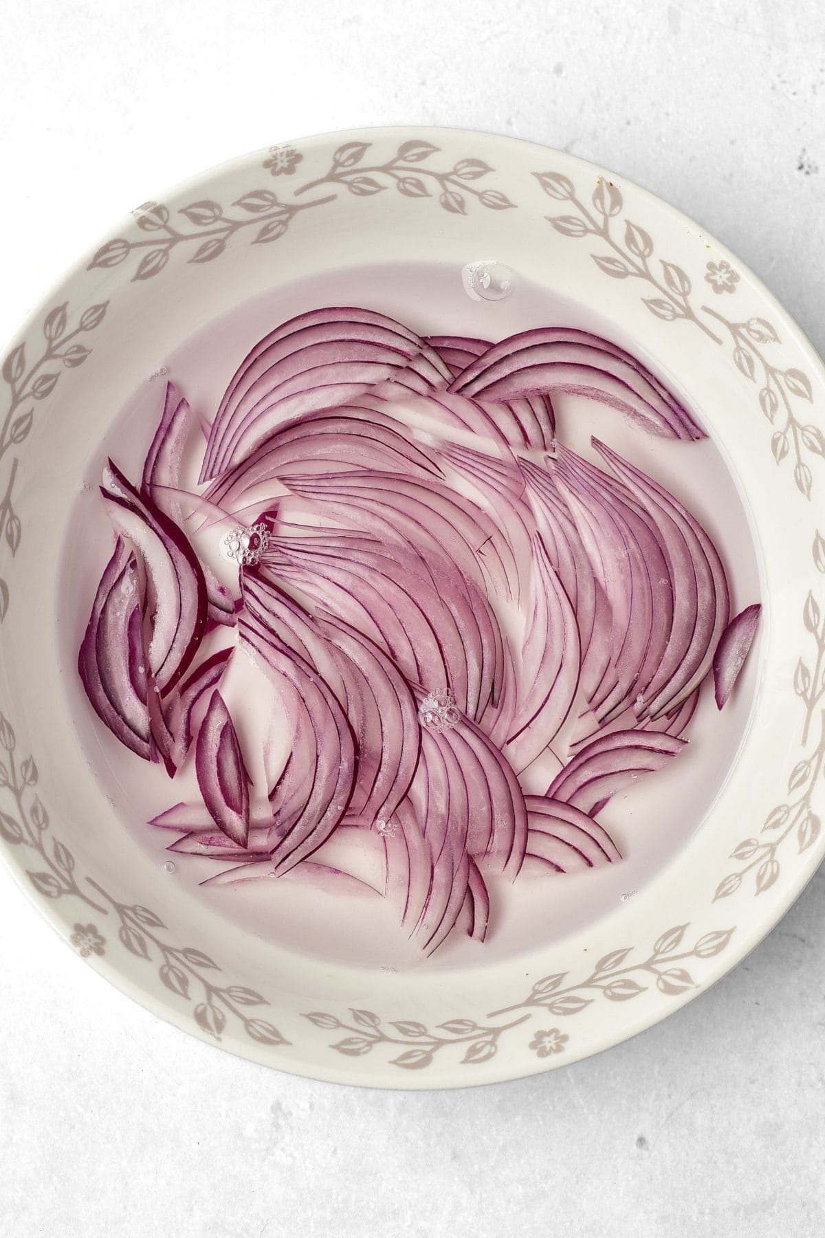 Sliced red onions soaking in water