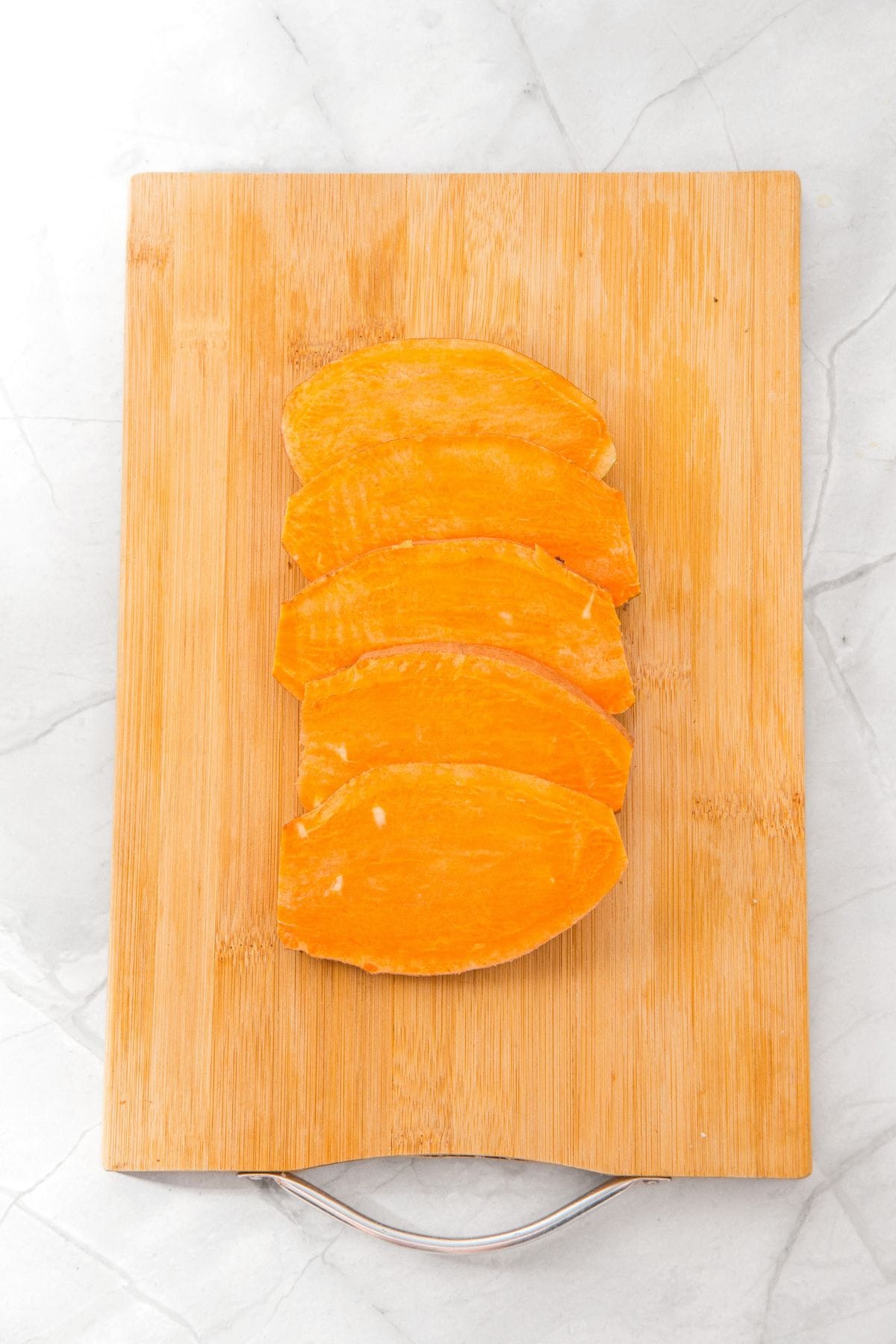 Sliced sweet potato on wooden board