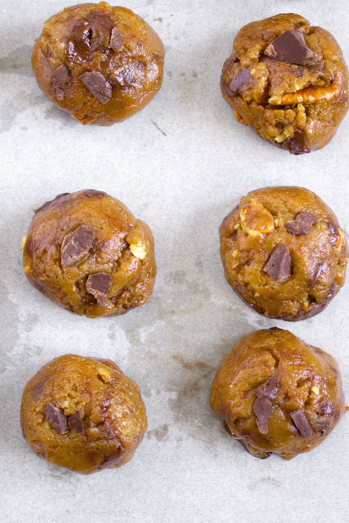 Cookie dough balls on parchment paper.