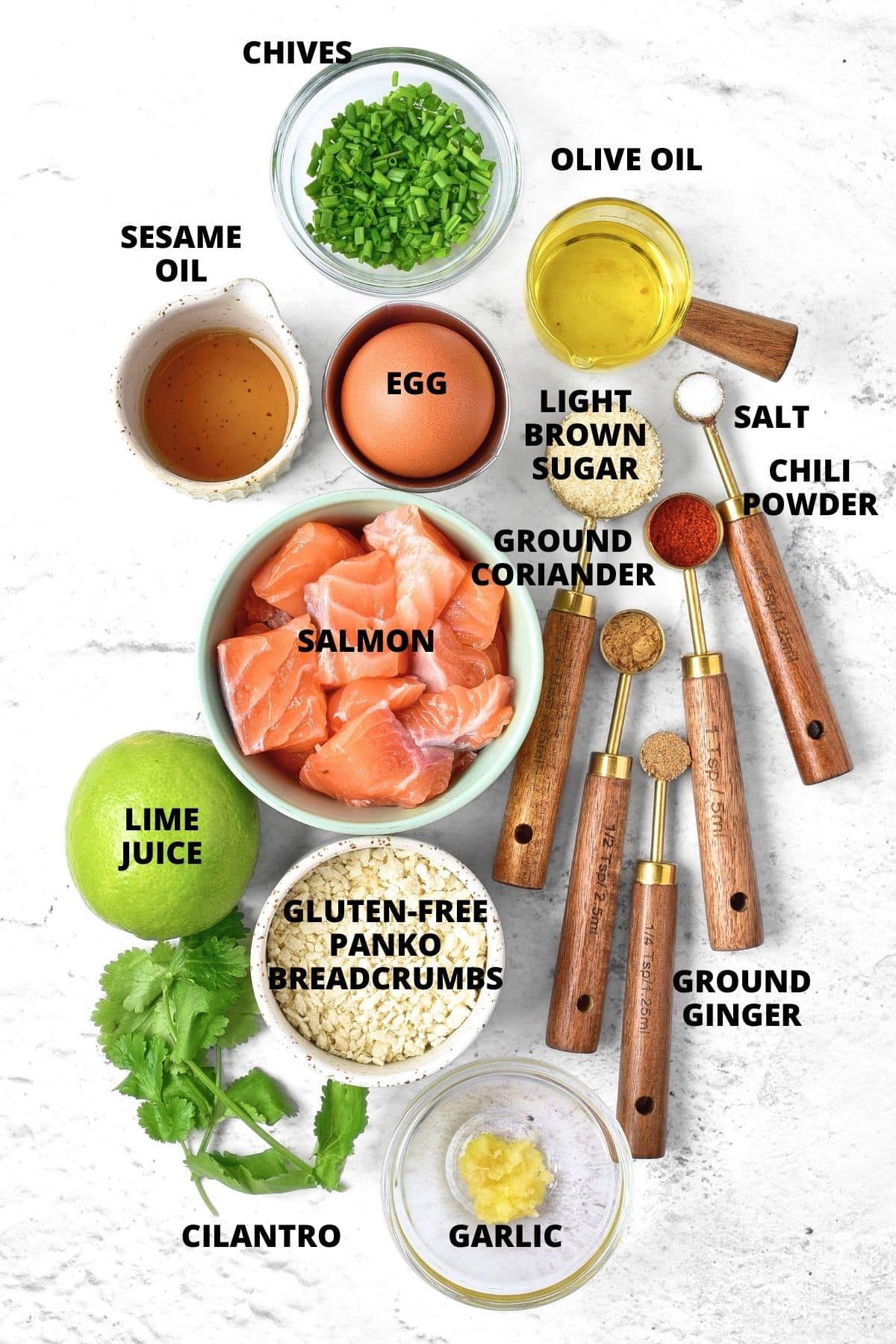 Ingredients for Thai salmon cakes recipe laid out on marble board.