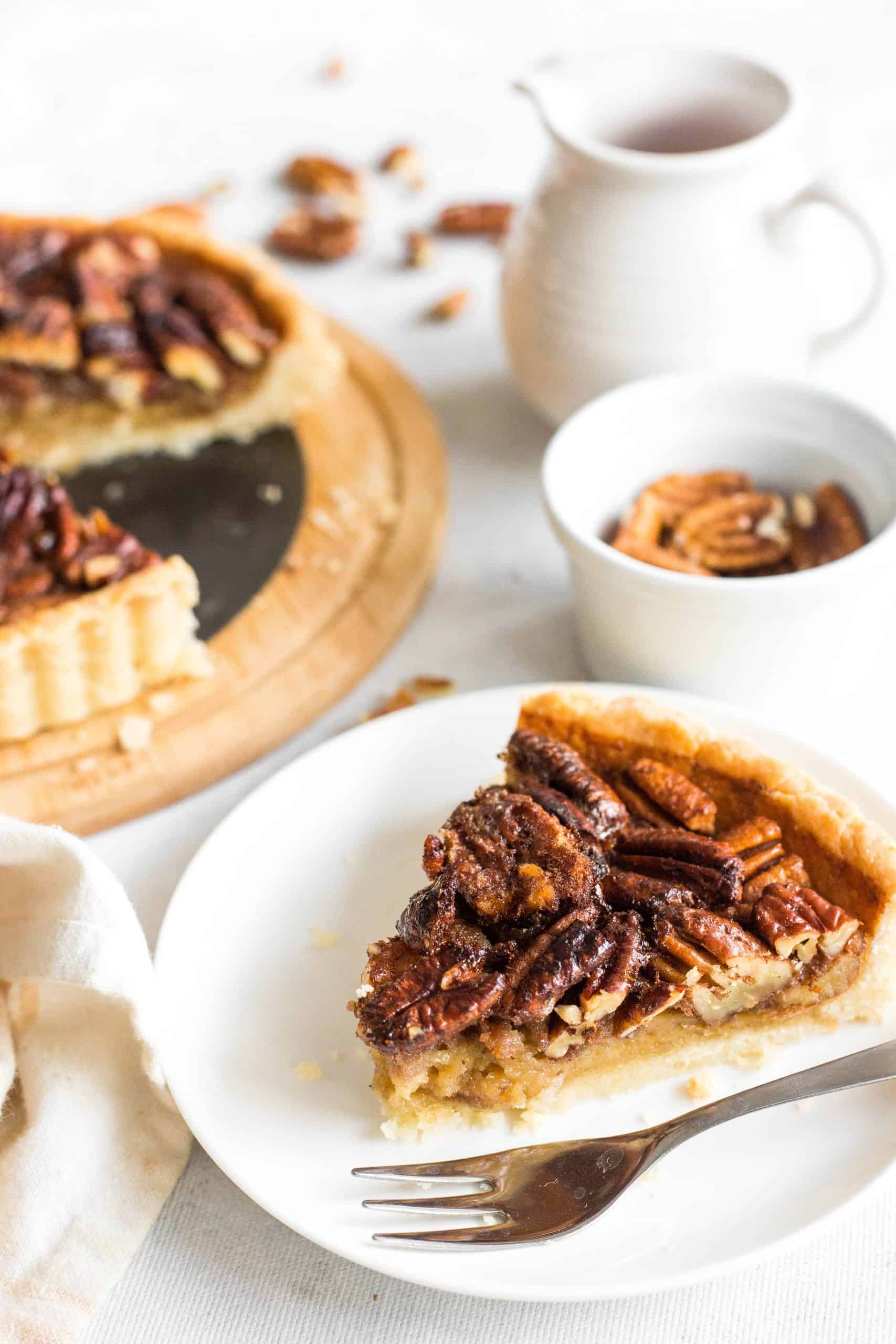 A slice of dairy-free pecan pie on a white plate.