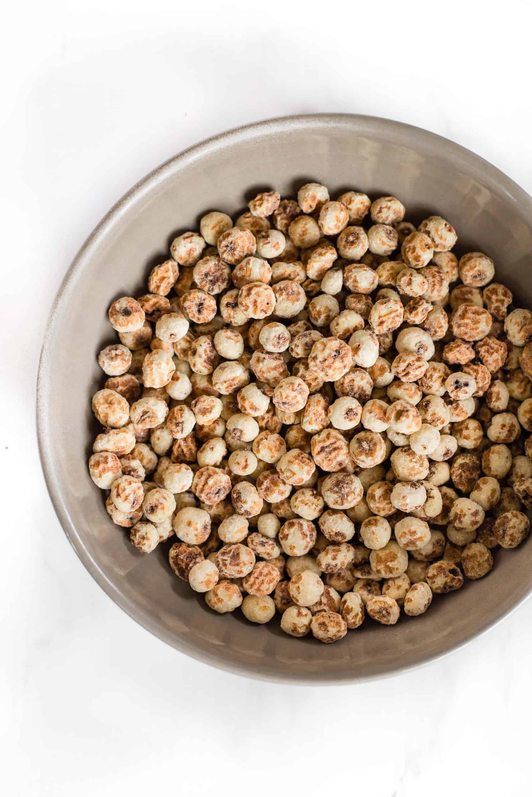 Raw peeled tiger nuts in a grey bowl.