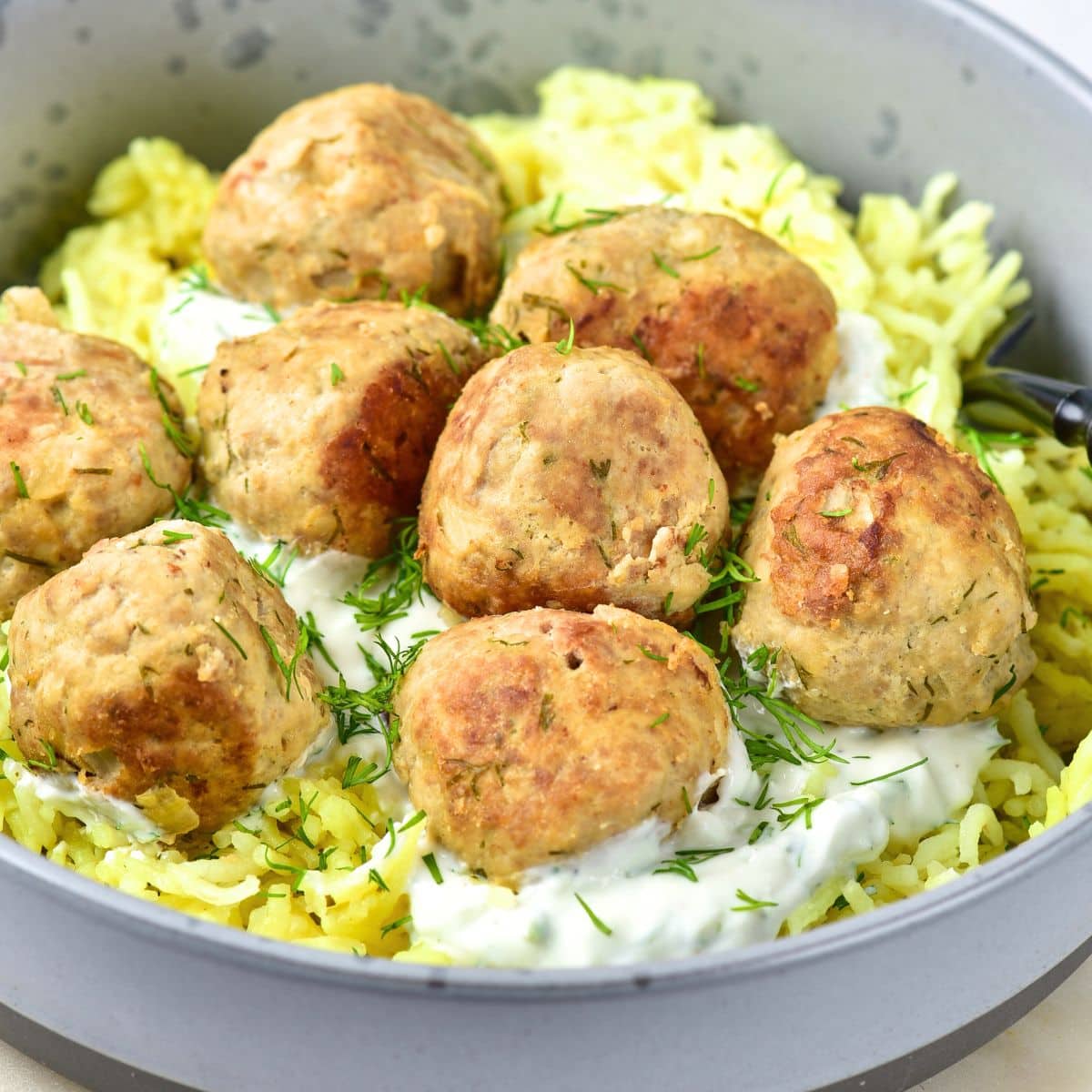 A bowl of turkey feta meatballs over rice