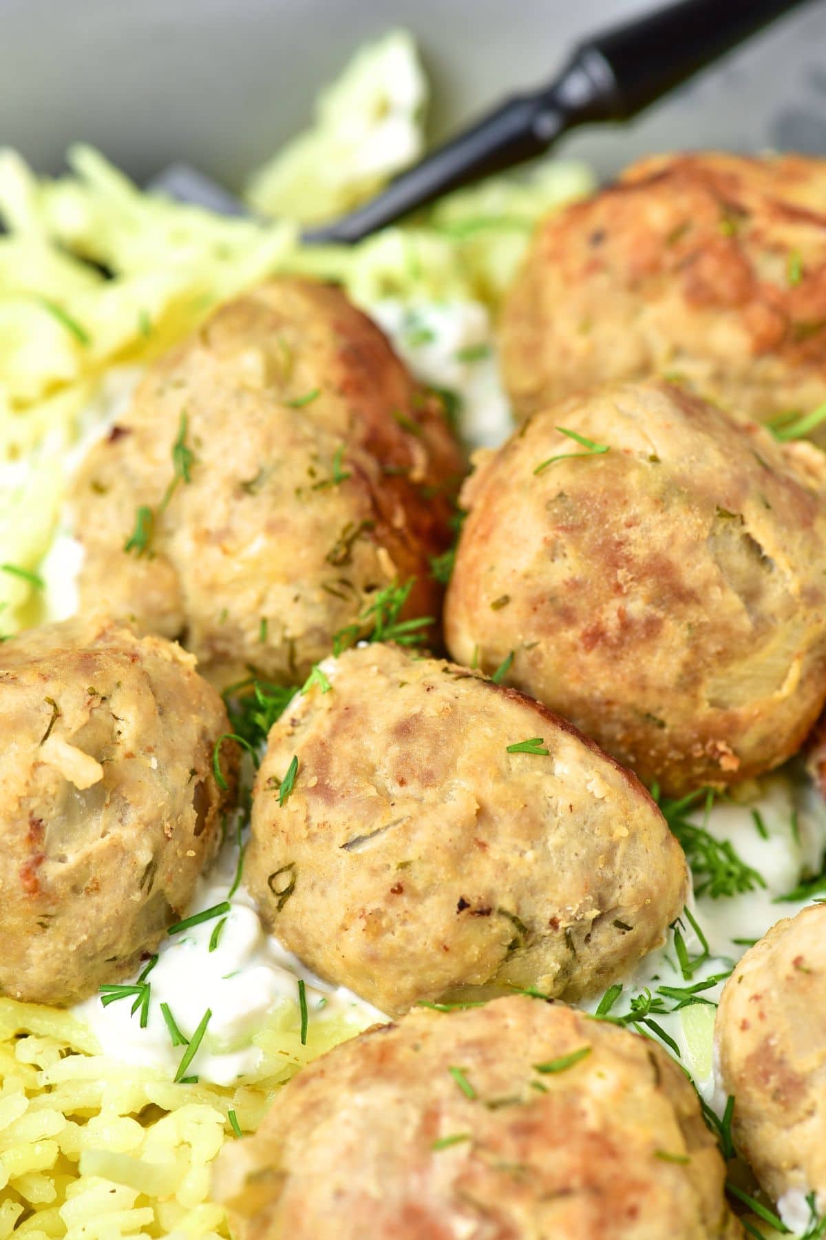 Up close shot of ground turkey feta meatballs garnished with dill.