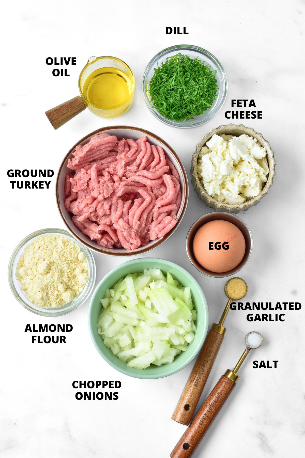 Ingredients for turkey feta meatballs recipe laid out on marble board.