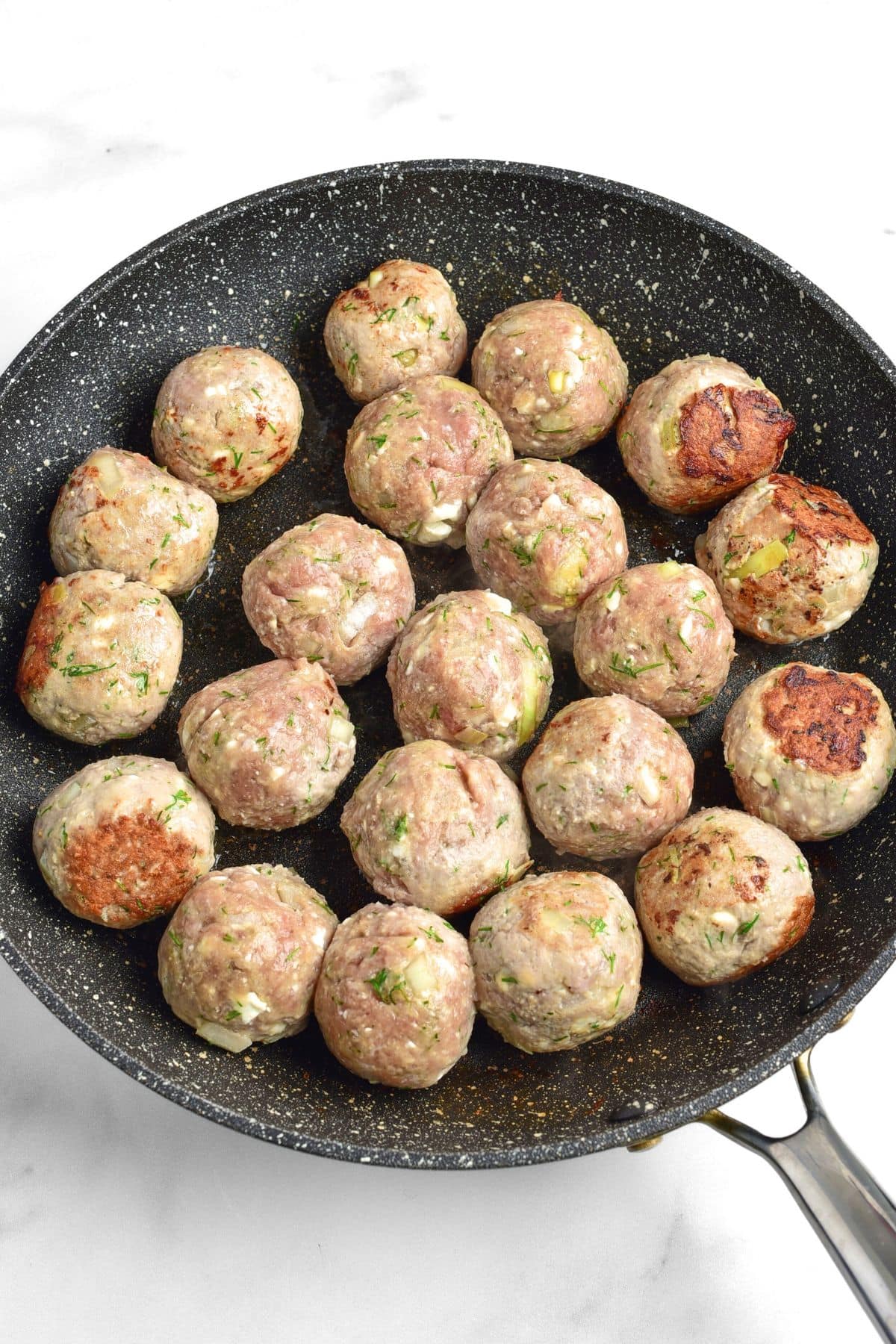 Cooked feta and turkey meatballs in a skillet