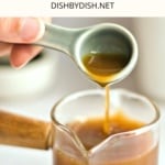 Pouring a spoonful of fish sauce into a jar.