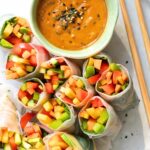 Cut veggie summer rolls and a bowl of peanut sauce