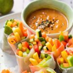 A plate of vegetarian summer rolls and peanut sauce