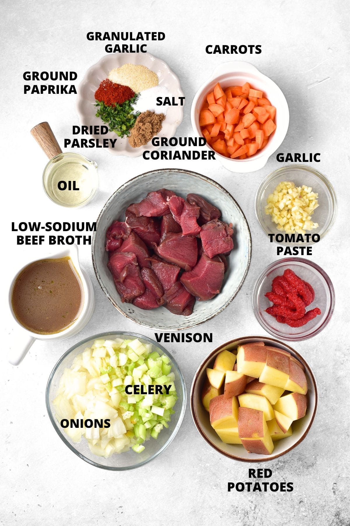 Ingredients for venison stew recipe laid out on marble board.