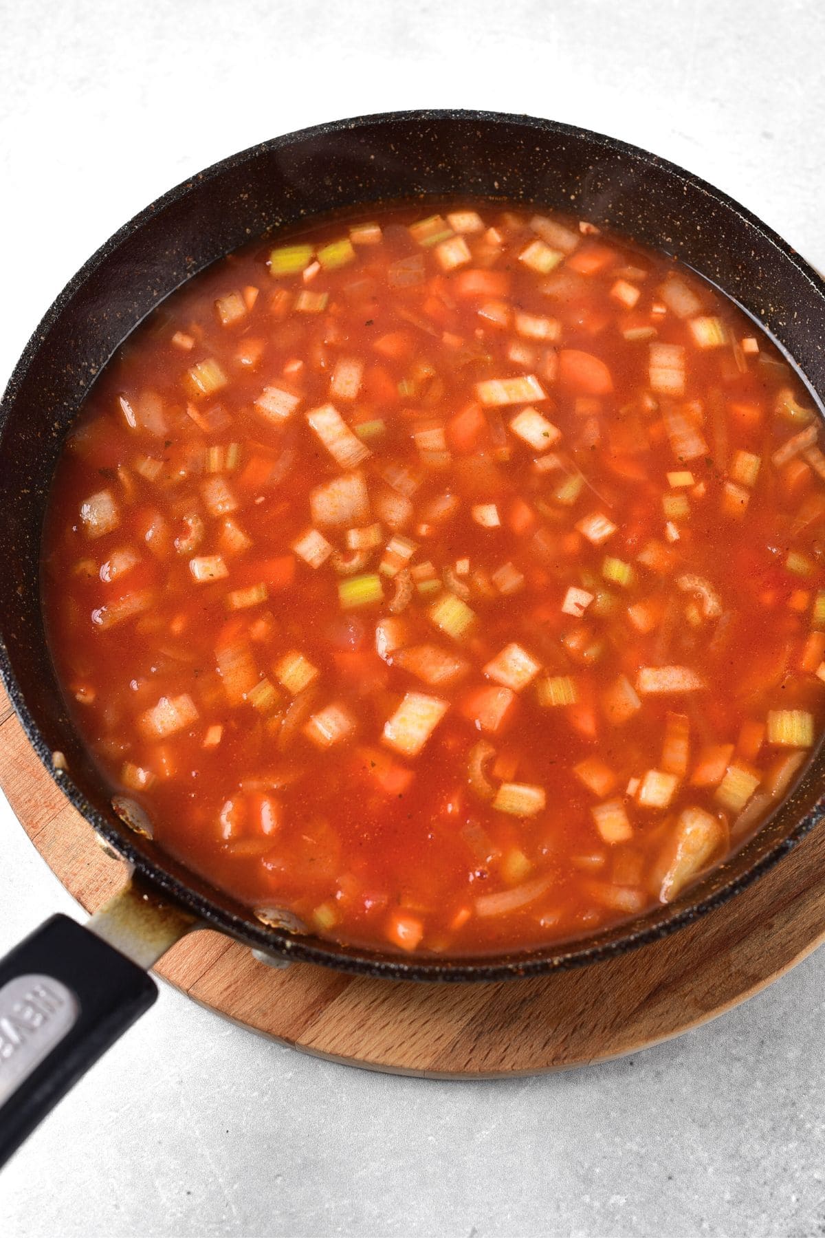 Veggies simmering in tomato-based broth