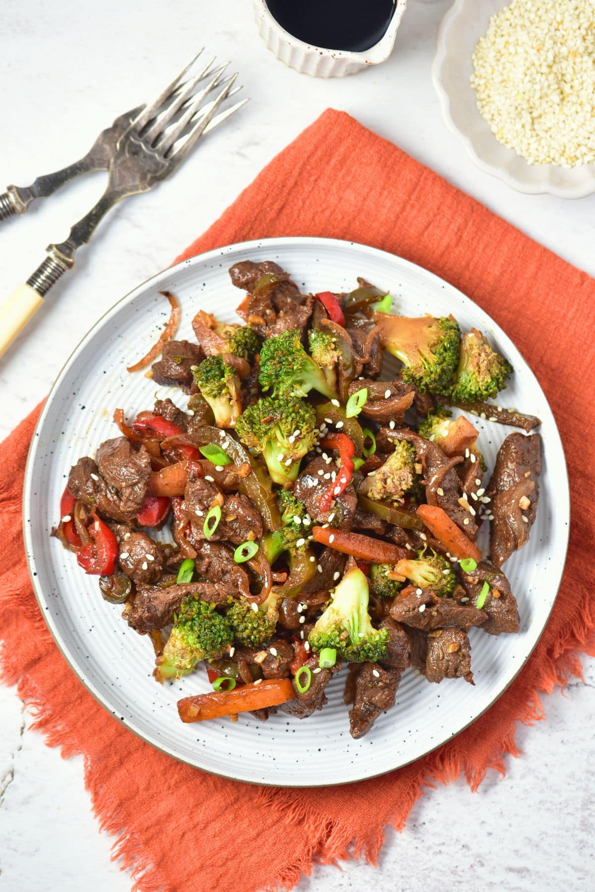 A plate of venison stir fry on red kitchen towel.