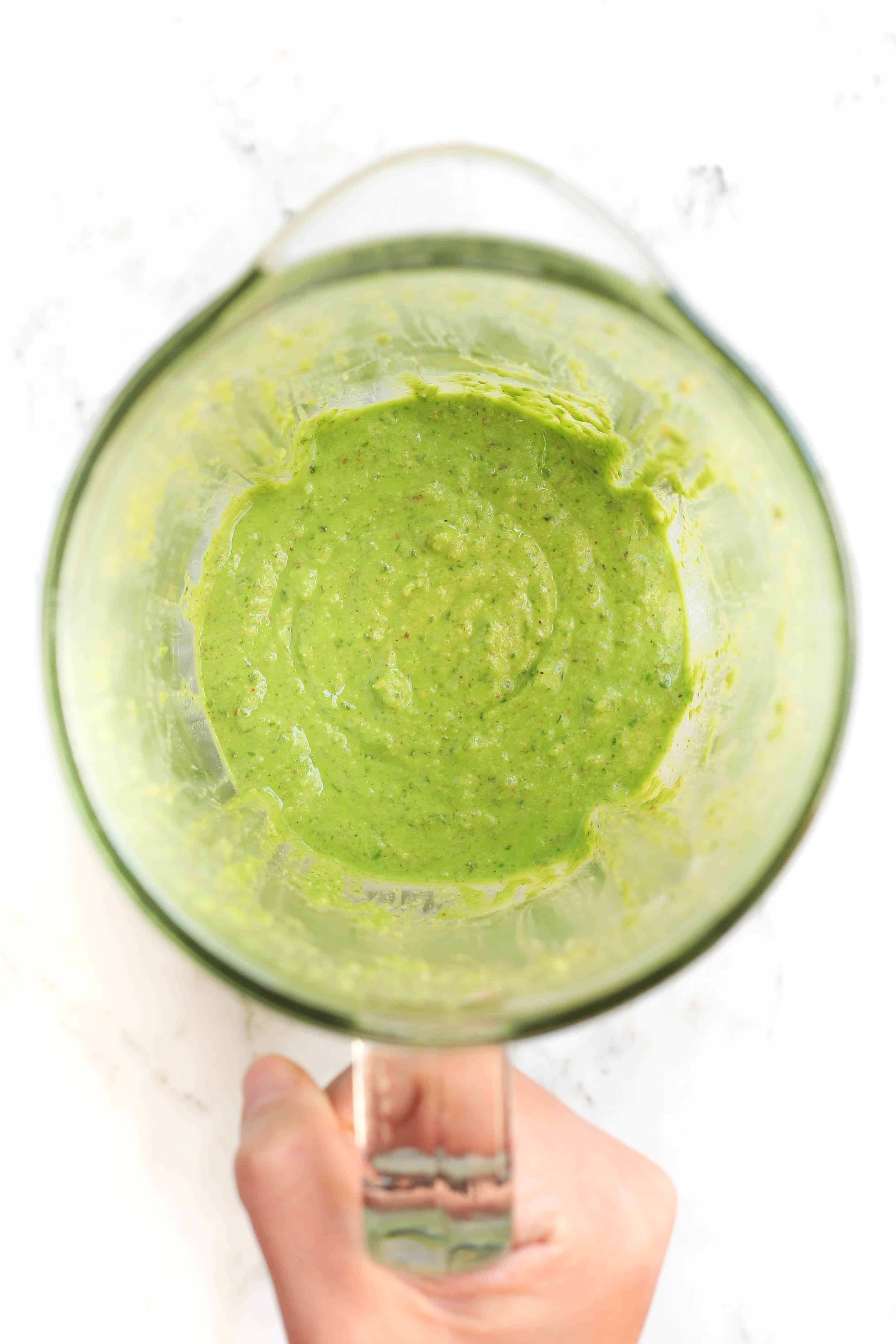 A blender with freshly made homemade pesto sauce.