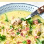 Top down view of a spoon in bowl of zuppa toscana