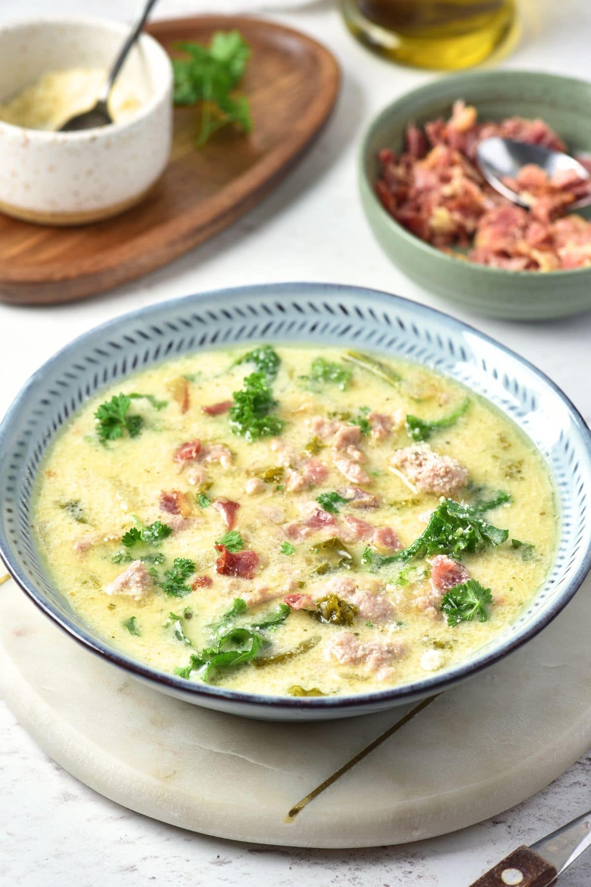 A bowl of Tuscan soup and a smaller bowl of bacon crumbles