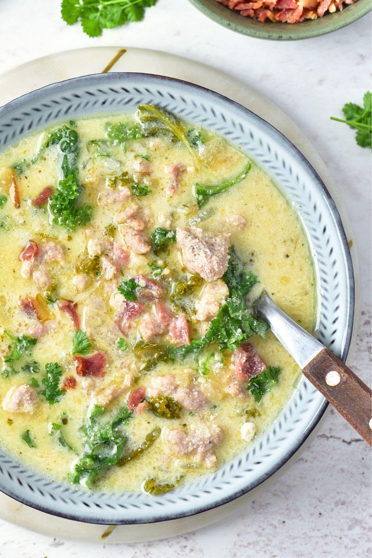 A spoon in a bowl of zuppa toscana (gluten-free)