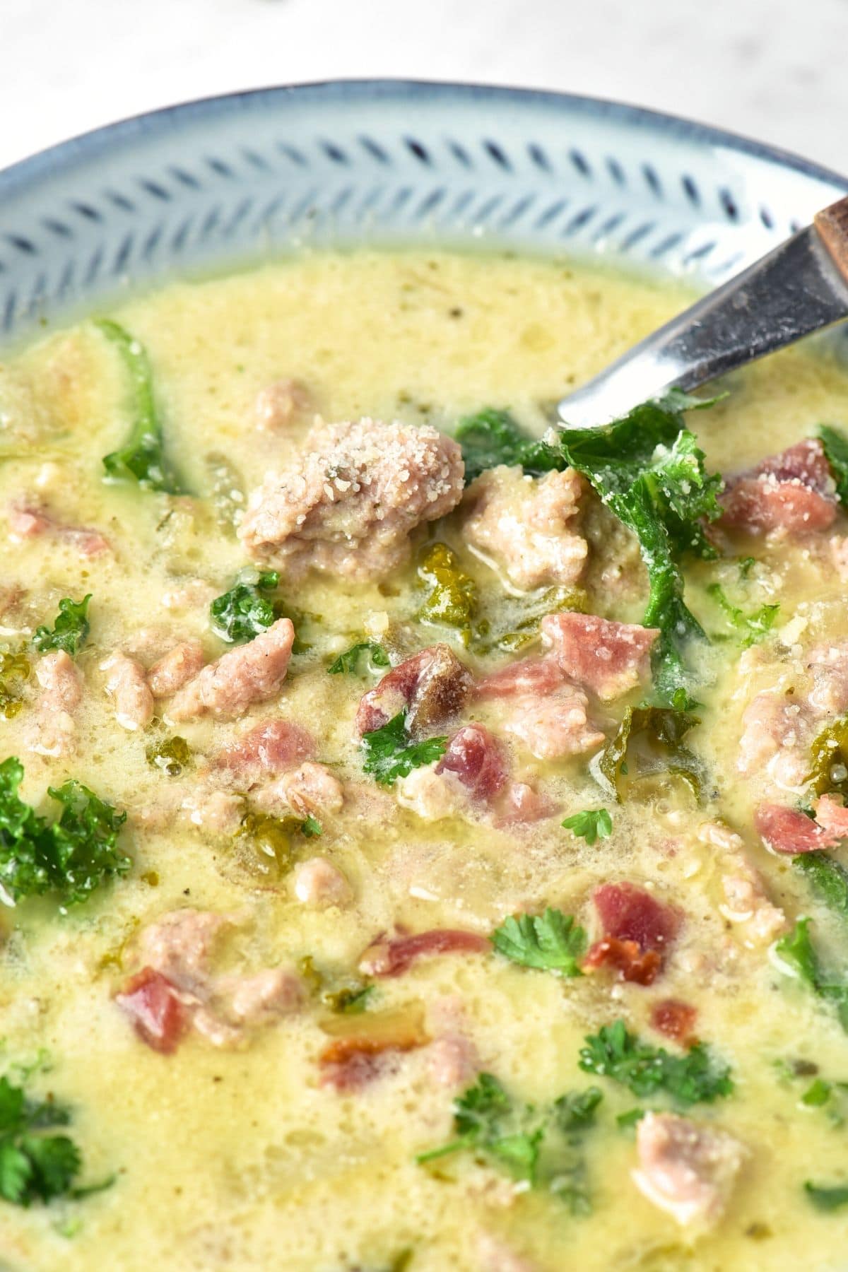 Up close view of a spoon in a bowl of zuppa toscana