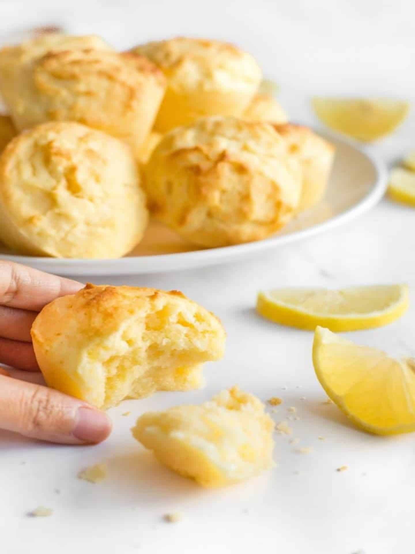 resized image of broken open lemon muffin and muffins on white board